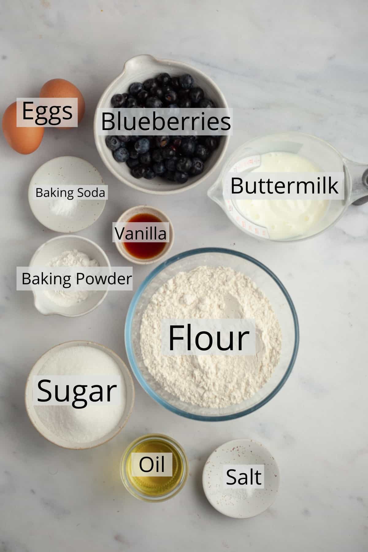 All the ingredients needed to make blueberry muffins, weighed out into small bowls.