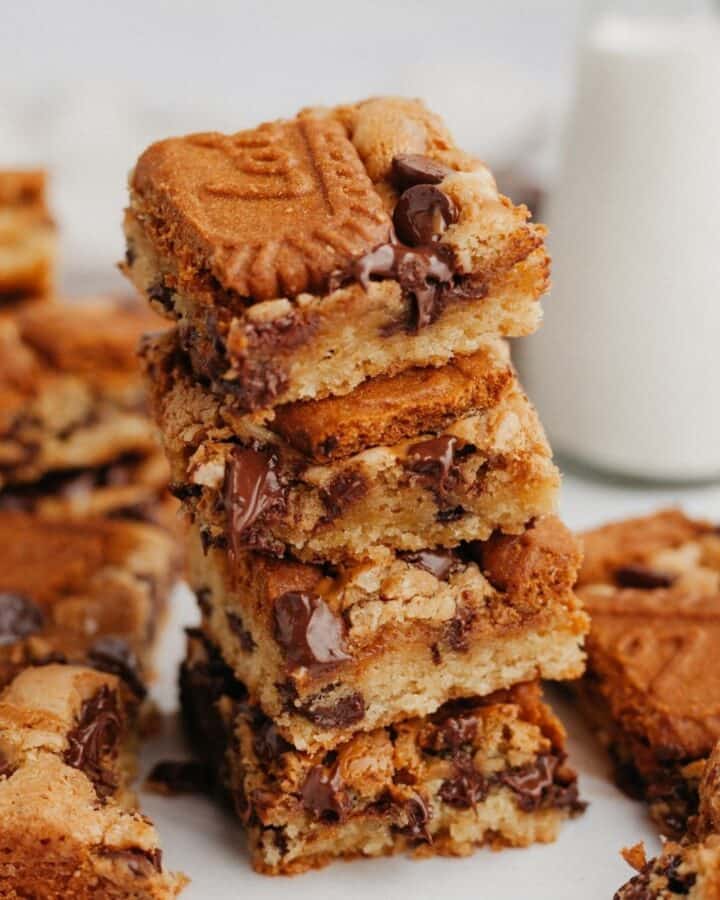 A stack of 4 Biscoff blondies on parchment paper.