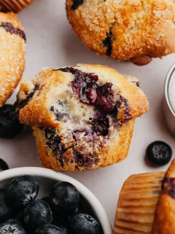 A close up of a blueberry muffin with a bite taken out of it.