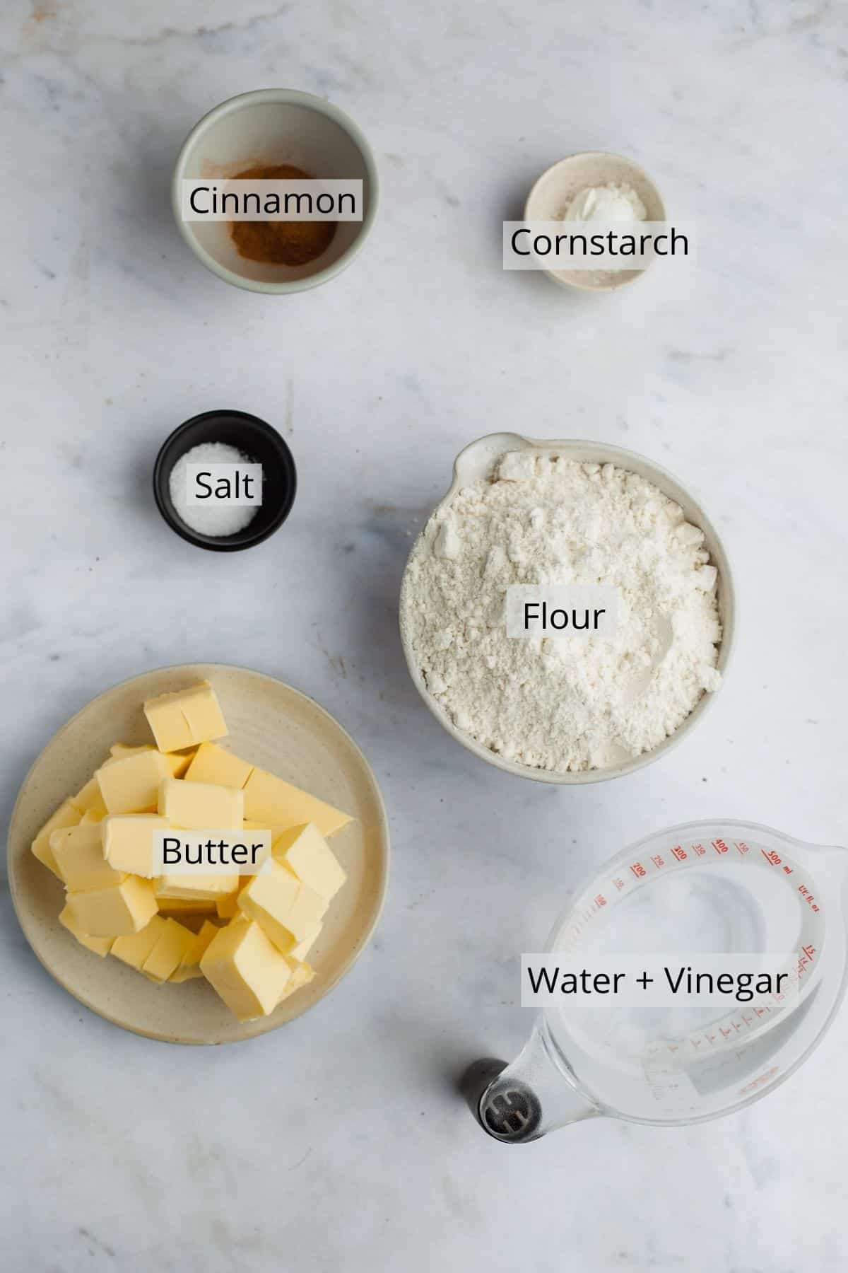 ingredients for cinnamon pie dough in an variety of small bowls and jugs
