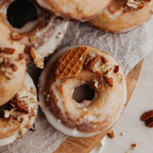 Glazed maple doughnuts on a wooden board