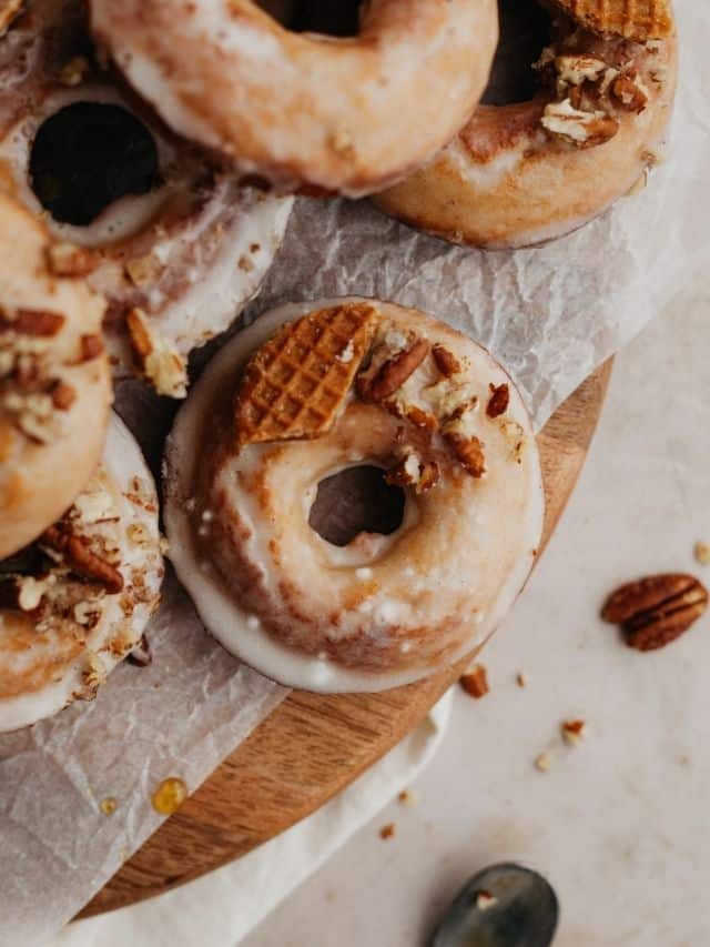 Glazed maple doughnuts on a wooden board