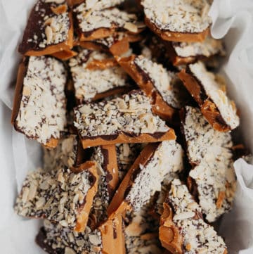 chopped pieces of almond toffee bark in parchment paper