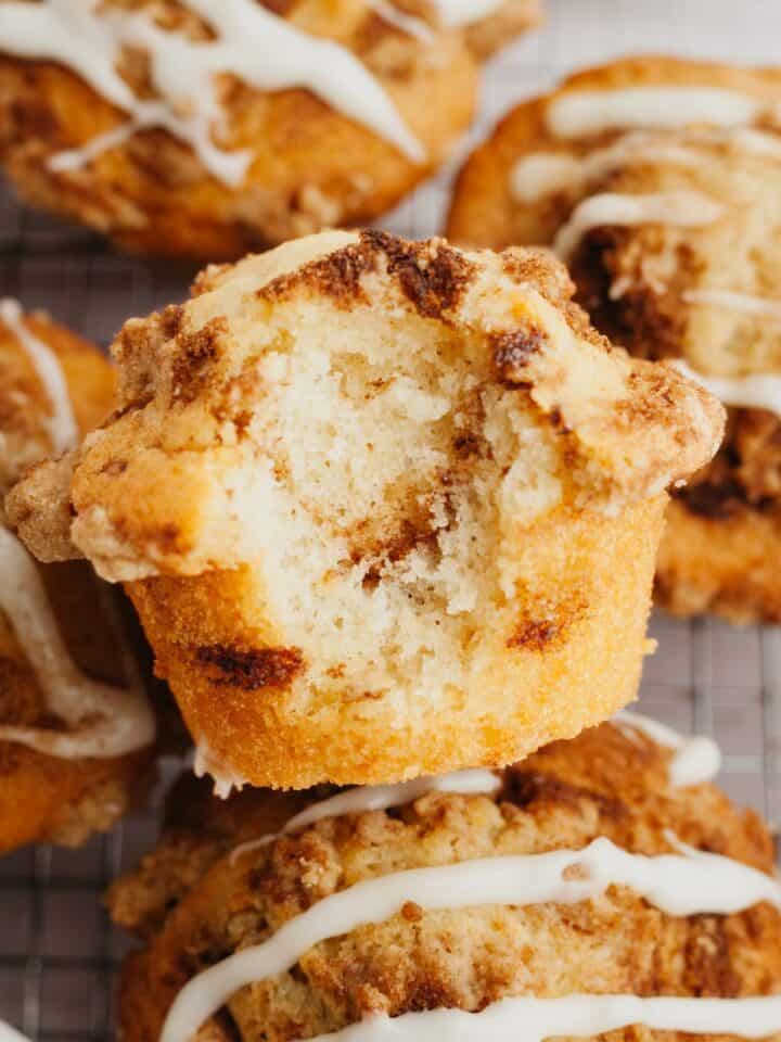 A close up of a cinnamon muffin with a bite taken out of it.