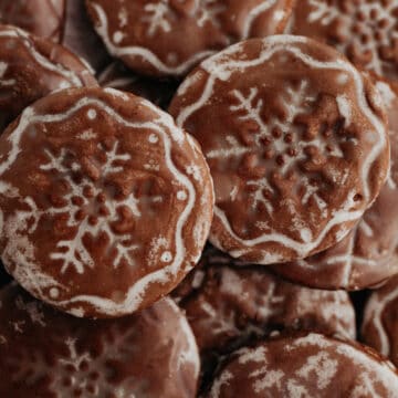 A pile of gingerbread cookies with a snowflake stamp on each one.