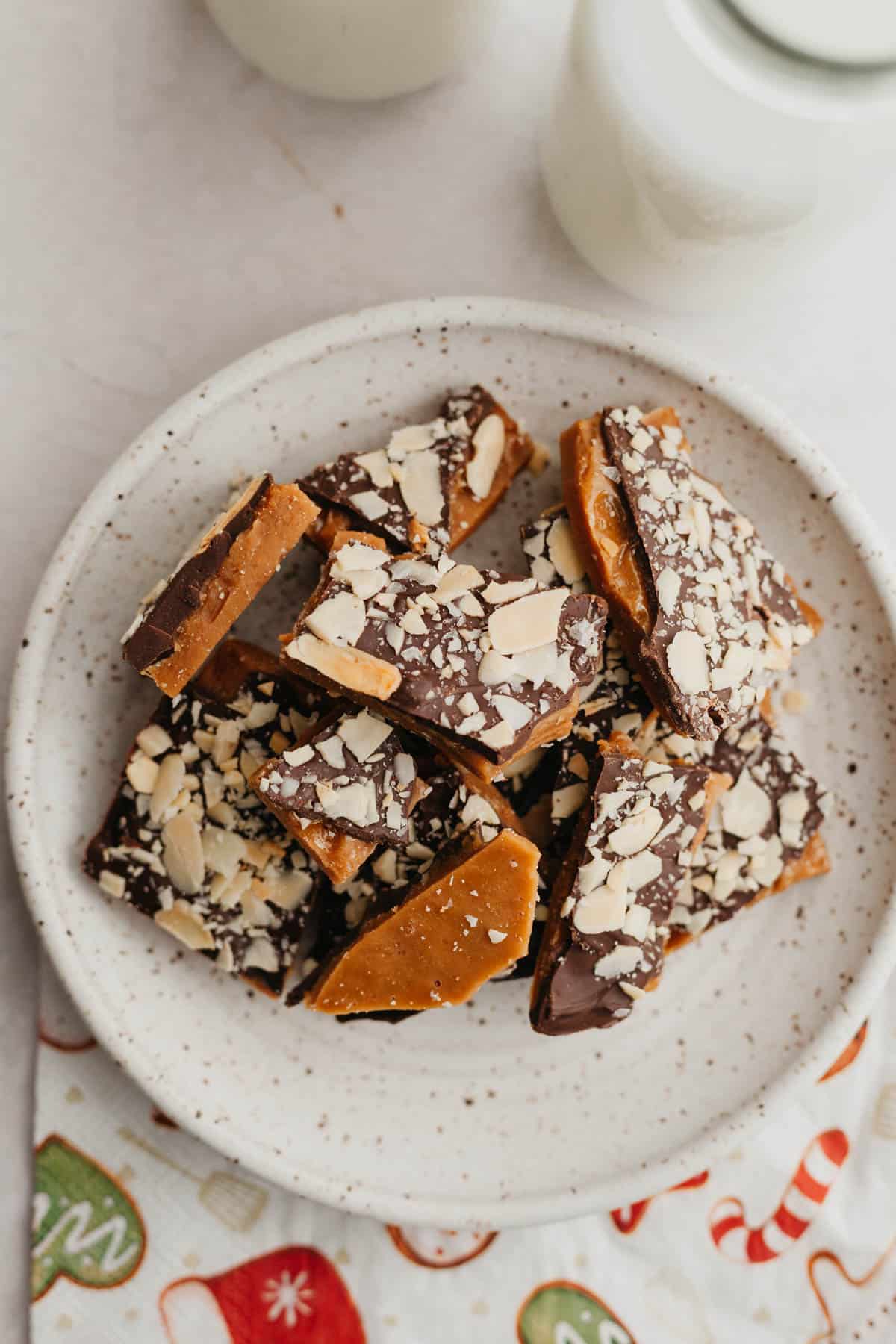A small plate with pieces of homemade almond toffee.