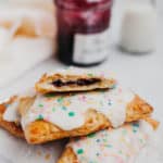 a stack of blueberry pop tarts with a jam jar behind