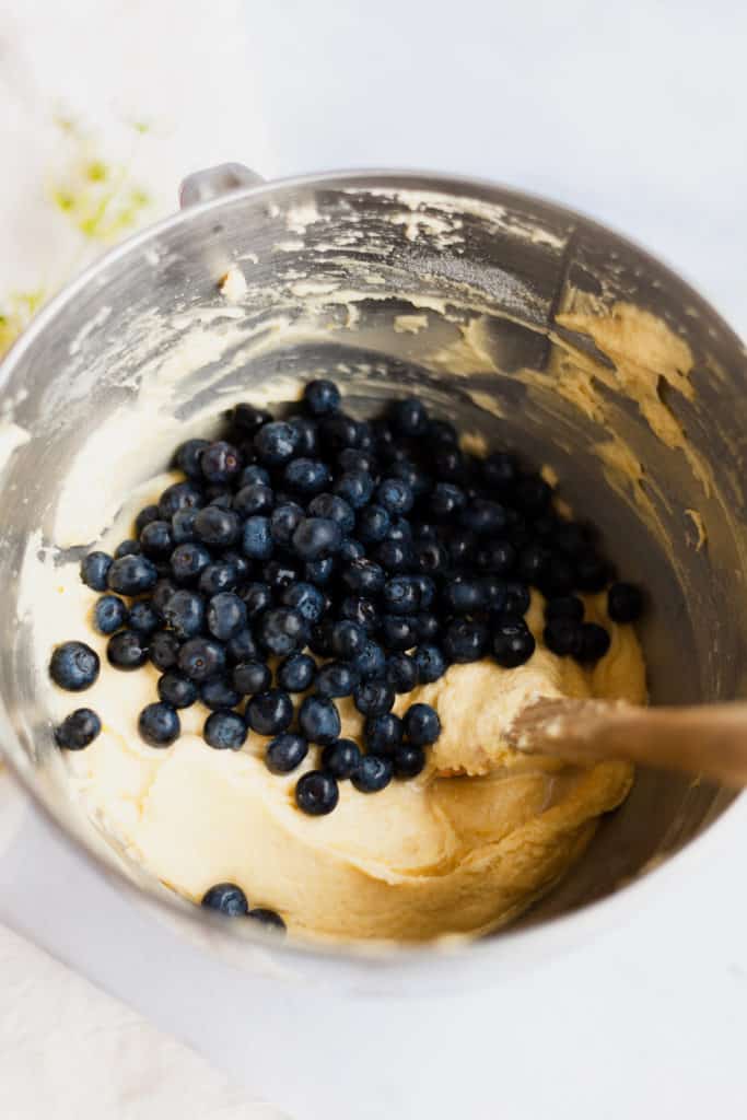 overhead view a mixing bowl with batter and blueberries