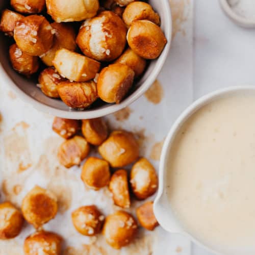 Overhead view of pretzel bites in a bowl, and a bowl of cheese sauce