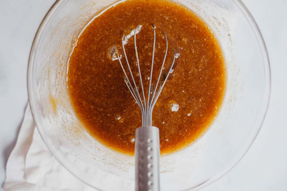 overhead view of batter in a mixing bowl with a whisk