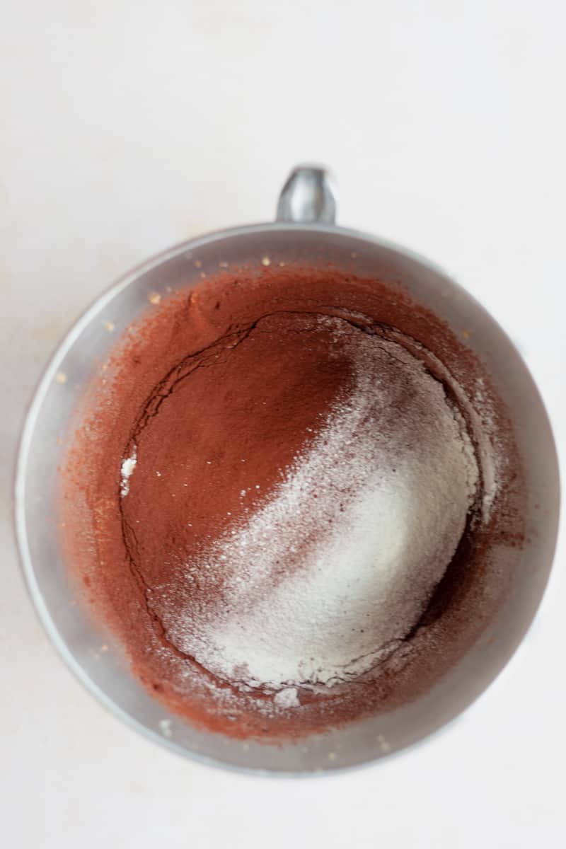 Overhead view of cocoa powder and flour in a large metal bowl