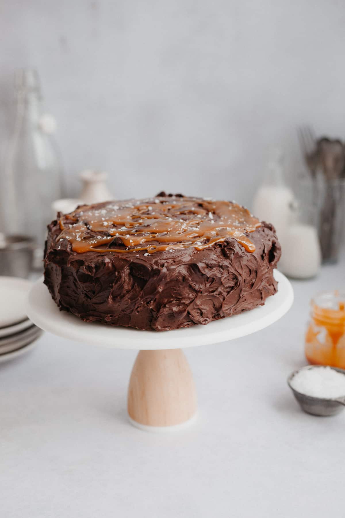 A chocolate cake with a caramel topping on a cake stand