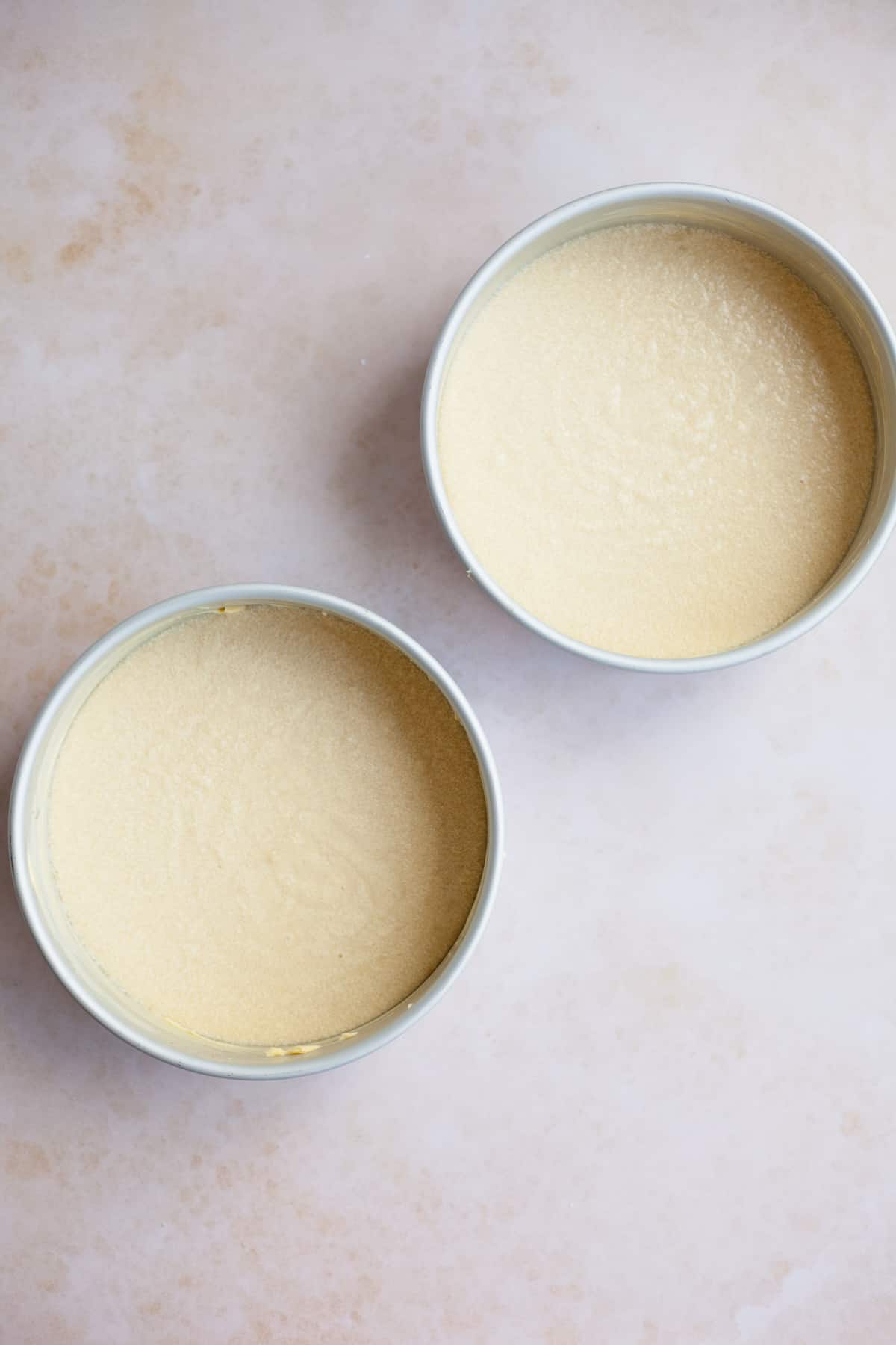 Two silver cake tins with unbaked cake batter