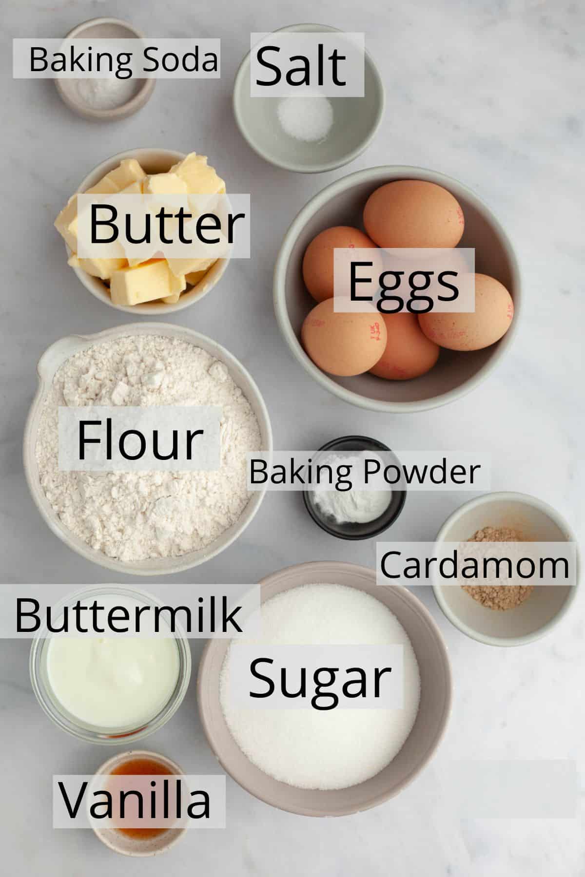 All the ingredients needed to make a cardamom cake weighed out into small bowls.
