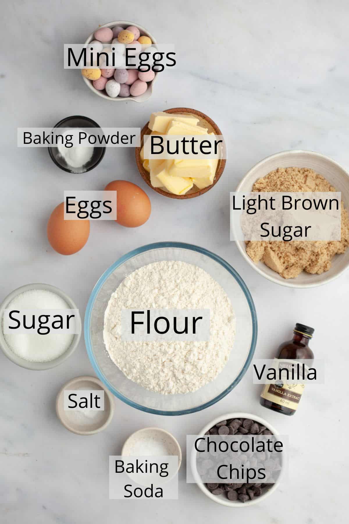 All the ingredients needed to make mini egg cookies weighed out into small bowls.