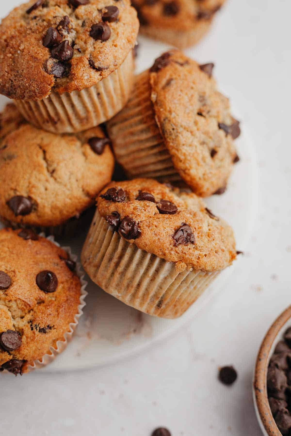 Several chocolate chip banana muffins on a marble plate.