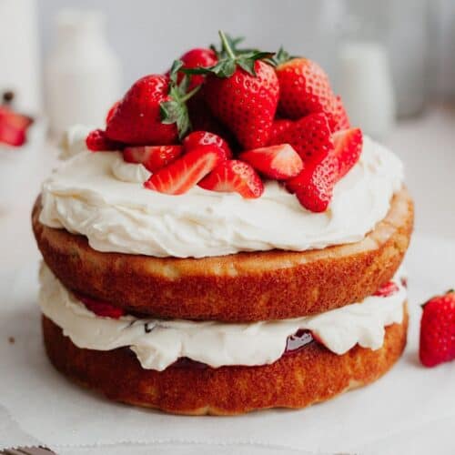 A strawberry filled cake on parchment paper