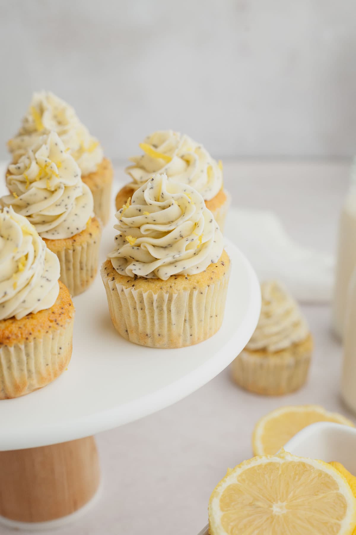 Lemon poppy seed cupcakes on a white cake stand.