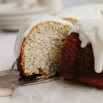 A slice of poppy seed bundt cake being lifted with a silver cake server