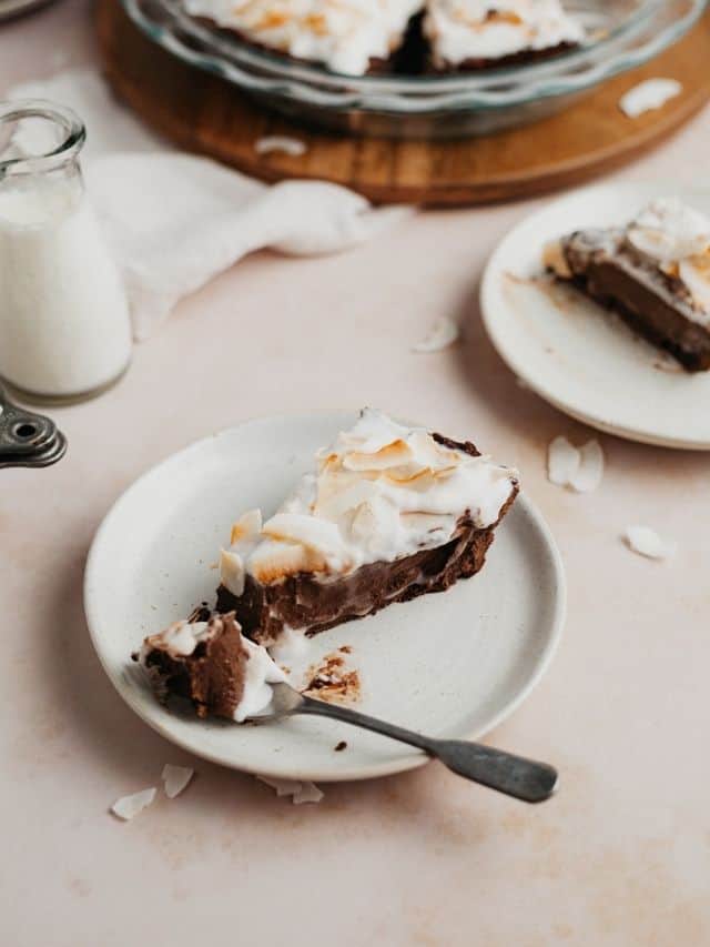 A slice of chocolate coconut pie on a small beige plate