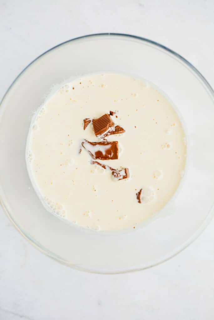 A pyrex bowl with heavy cream and chopped chocolate