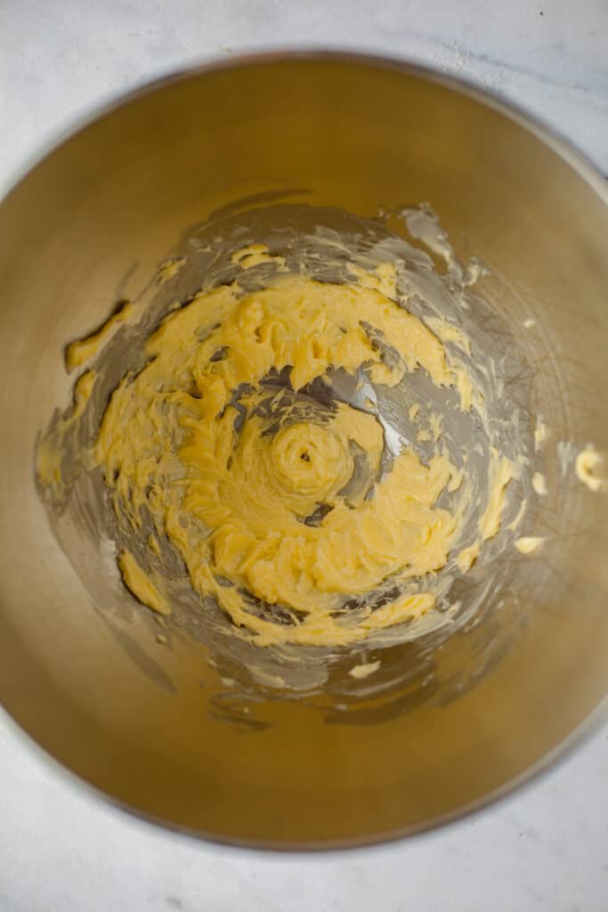 A silver mixing bowl with creamed butter