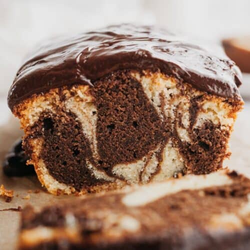 A close up of a marble loaf cake covered with chocolate ganache.