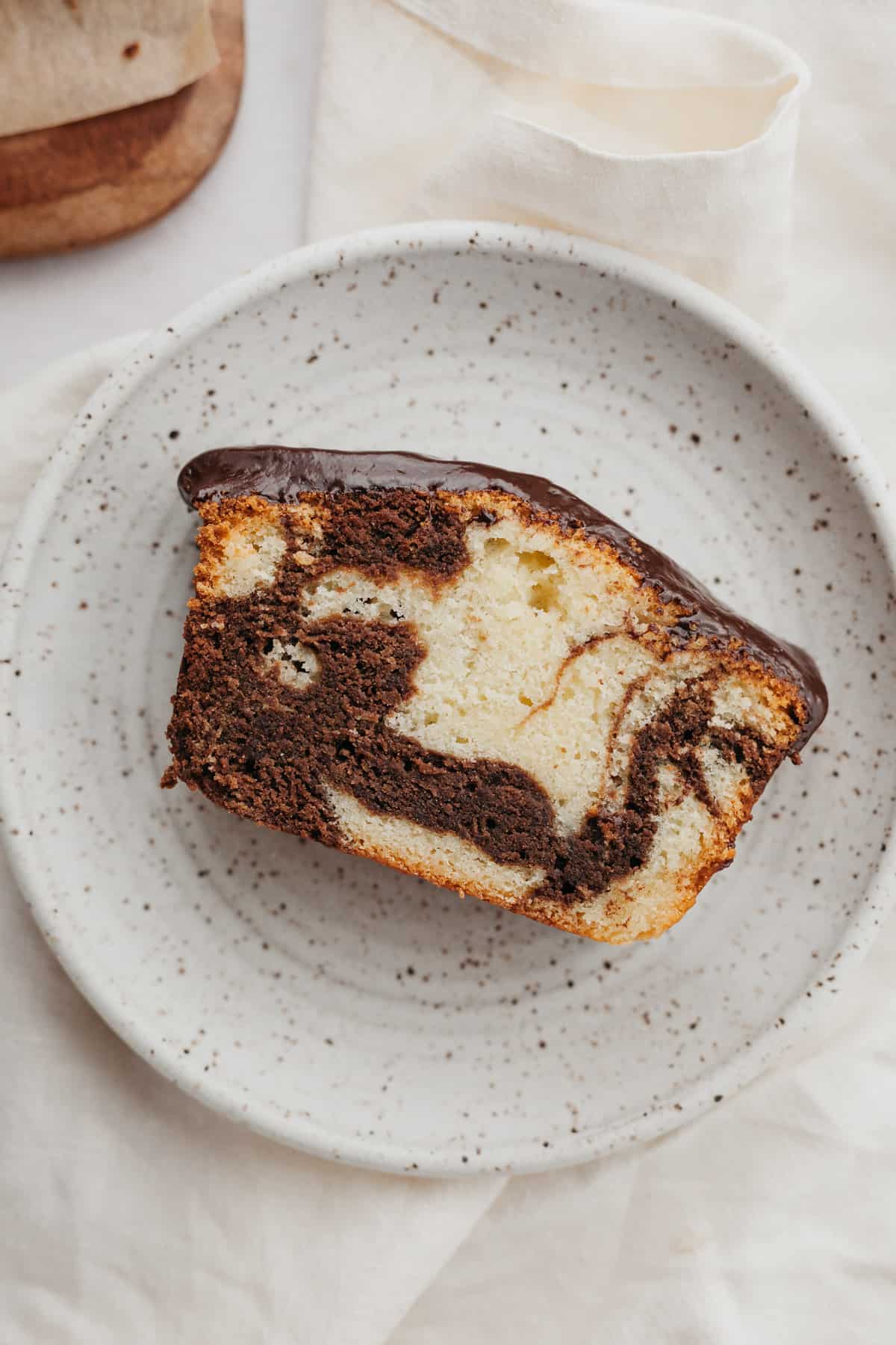 A slice of marble loaf cake on a small plate.
