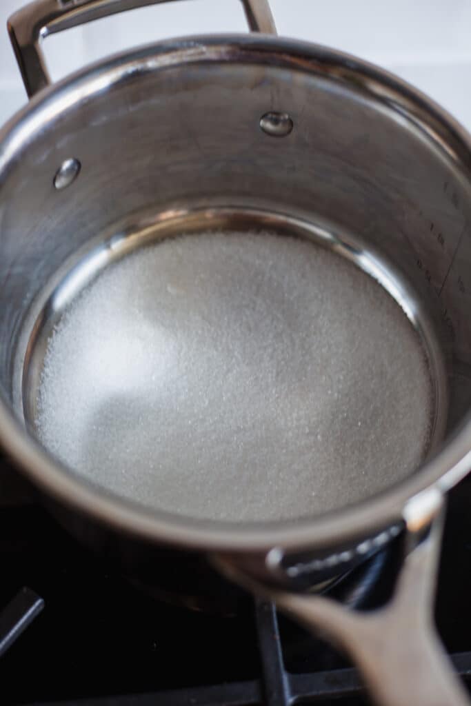 A small silver saucepan with a thin layer of sugar at the bottom