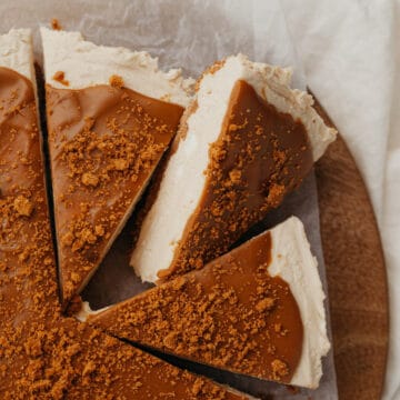Three slices of biscoff cheesecake on a wooden circular board