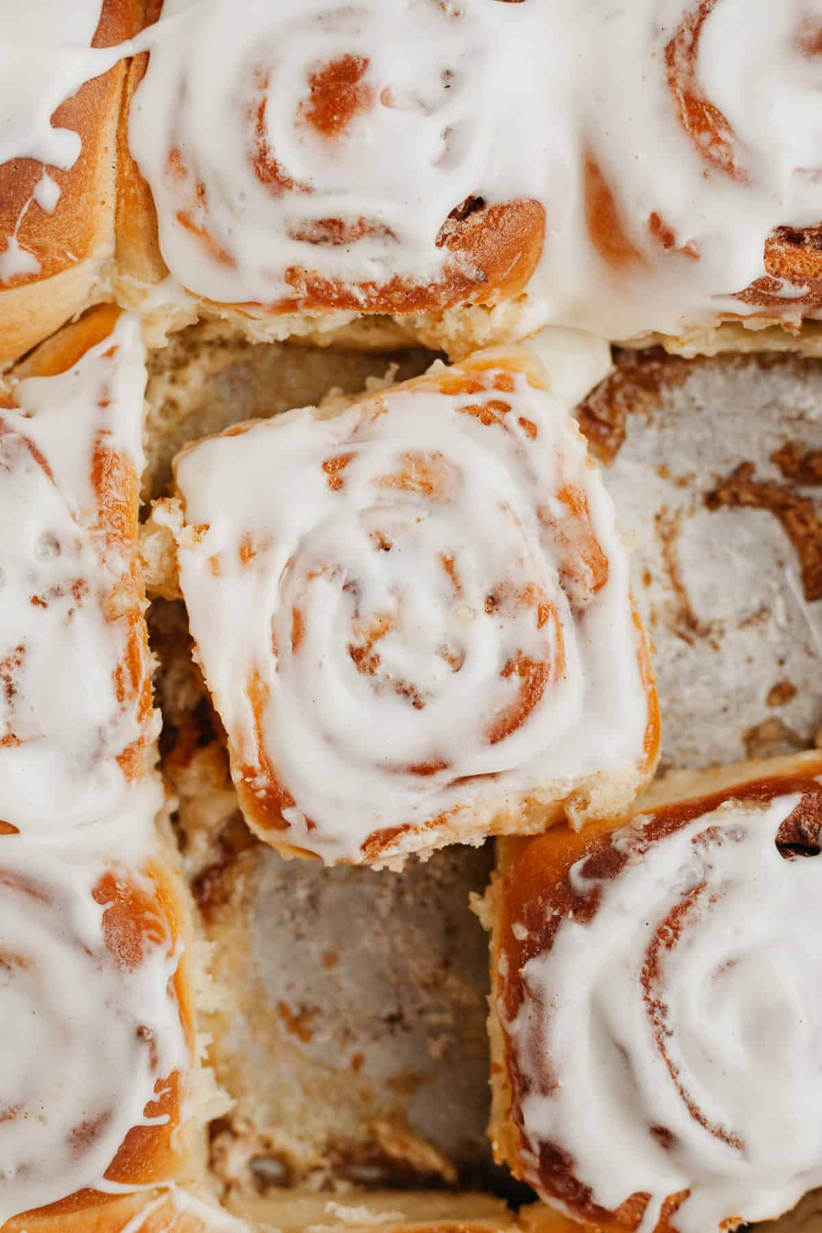 Cinnamon rolls in a pan, covered in a cream cheese glaze.