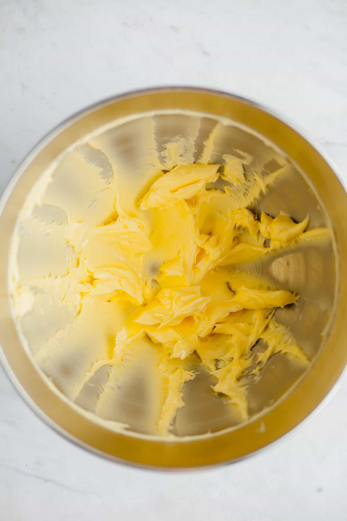 Creamed butter in a silver mixing bowl
