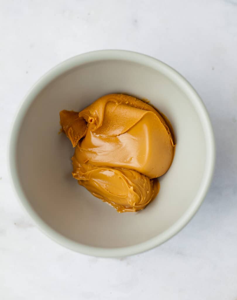A gray bowl with melted peanut butter in it