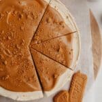 A biscoff cheesecake with 3 slices cut.