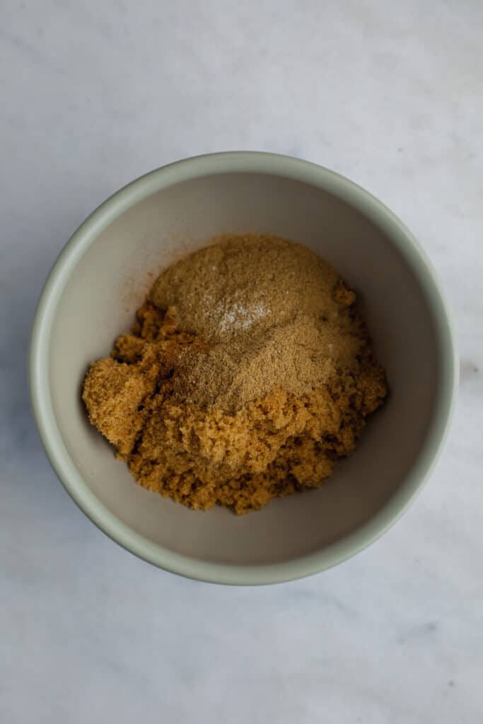 A small grey bowl with cinnamon, cardamom and brown sugar in it