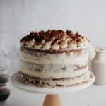 A tiramisu layer cake on a white cake stand