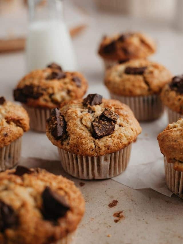 Peanut butter muffins with chocolate chunks on parchment paper