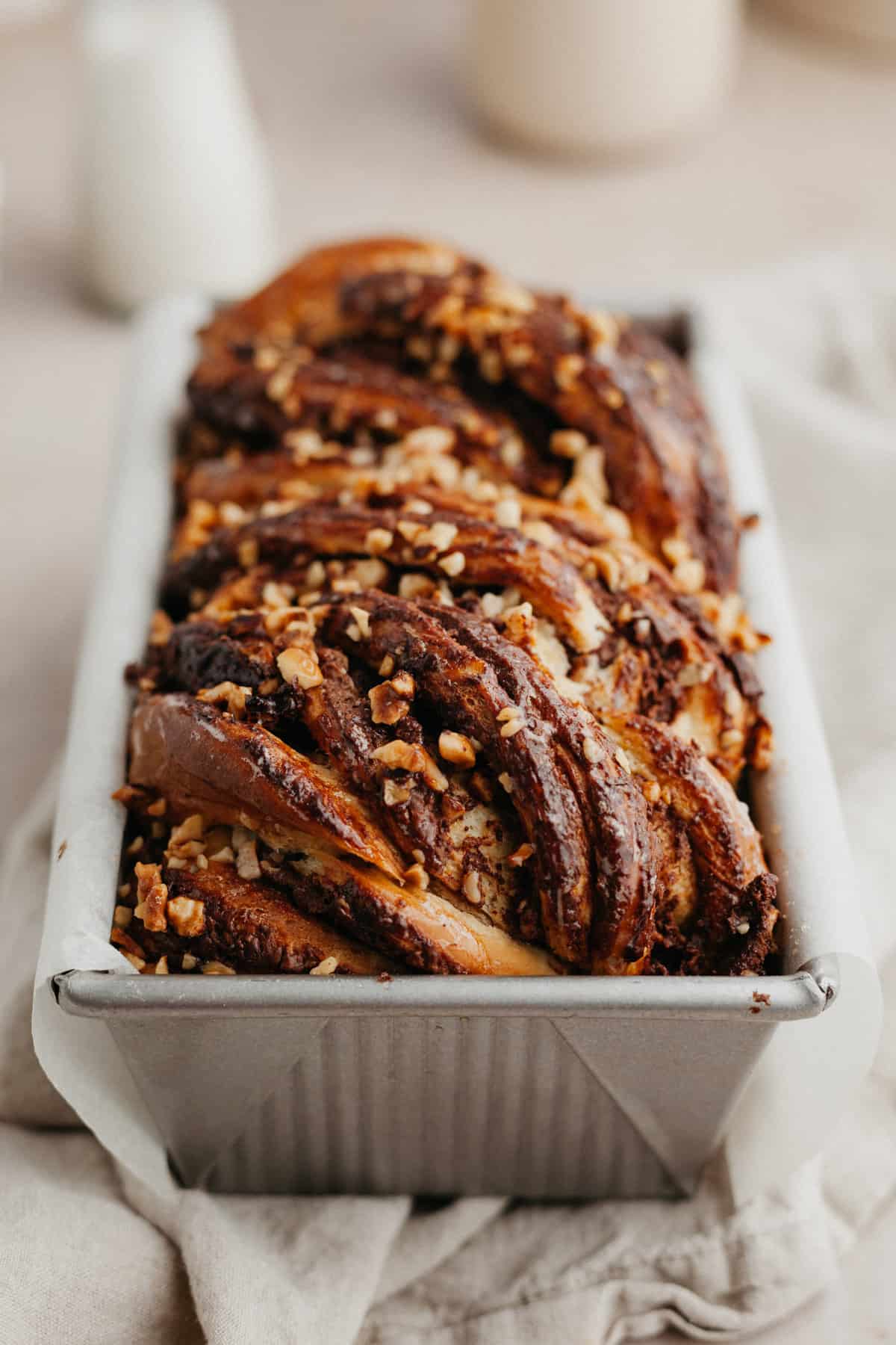 A close up of a baked babka in a loaf pan.