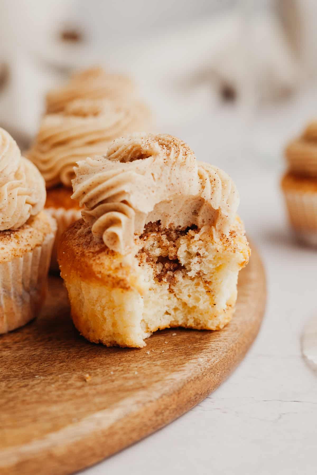 A cinnamon swirl cupcake with a bite taken out of it.