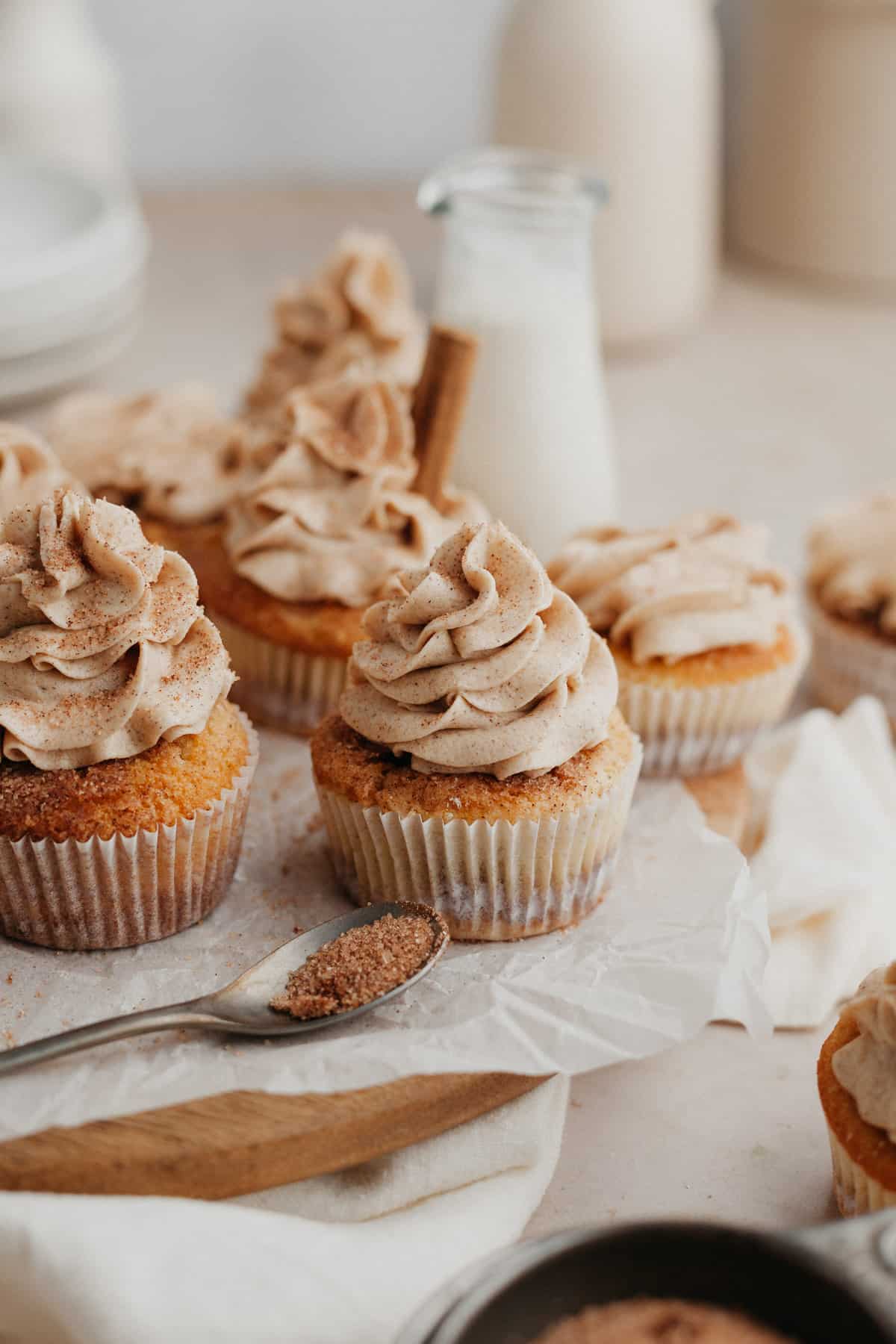 Several frosted cupcakes on parchment paper.