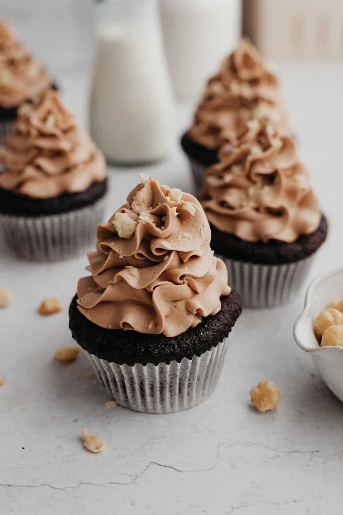 chocolate frosted chocolate cupcakes, sprinkled with chopped hazelnuts.