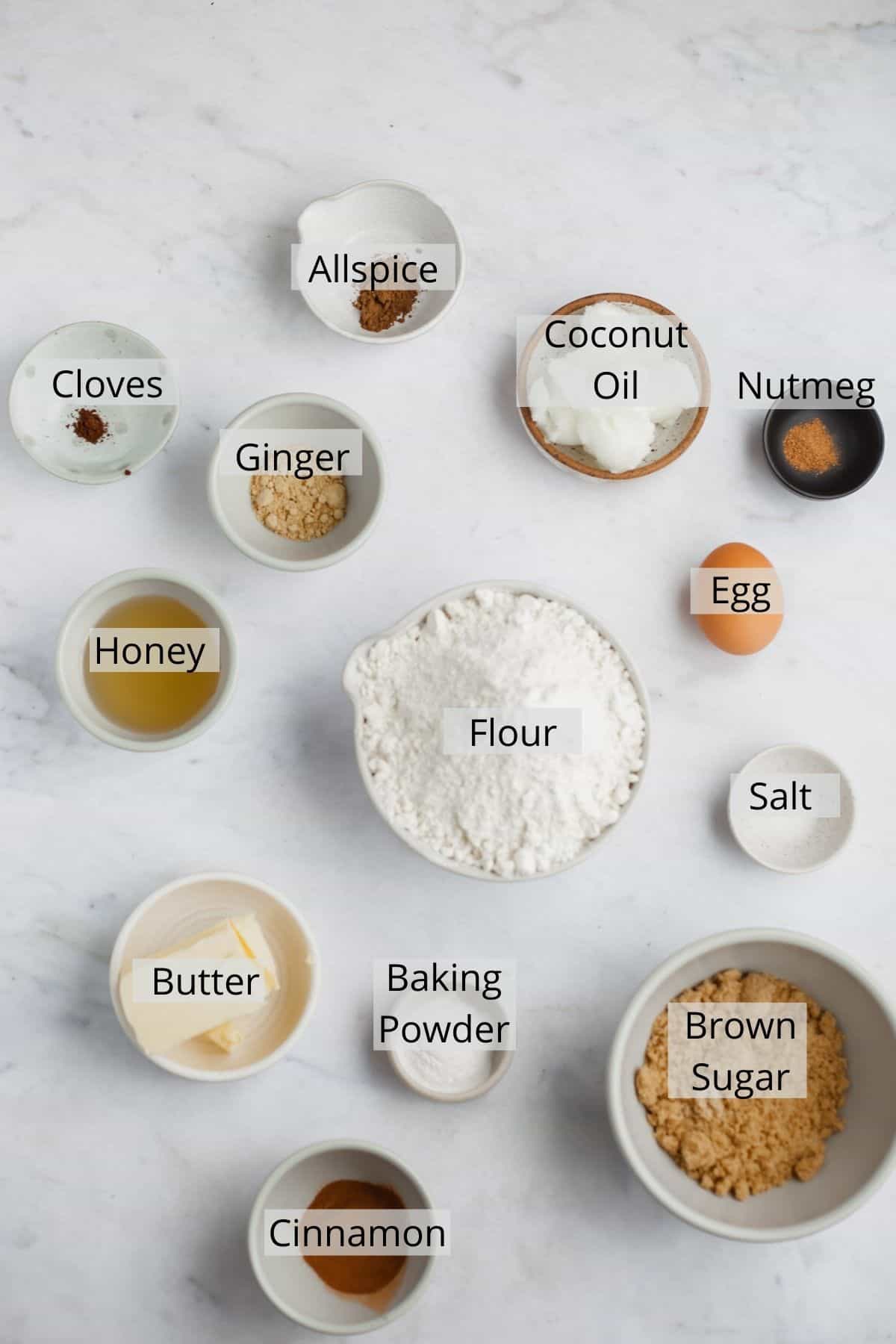 all the ingredients needed for gingerbread cookies without molasses weighed out in small bowls.
