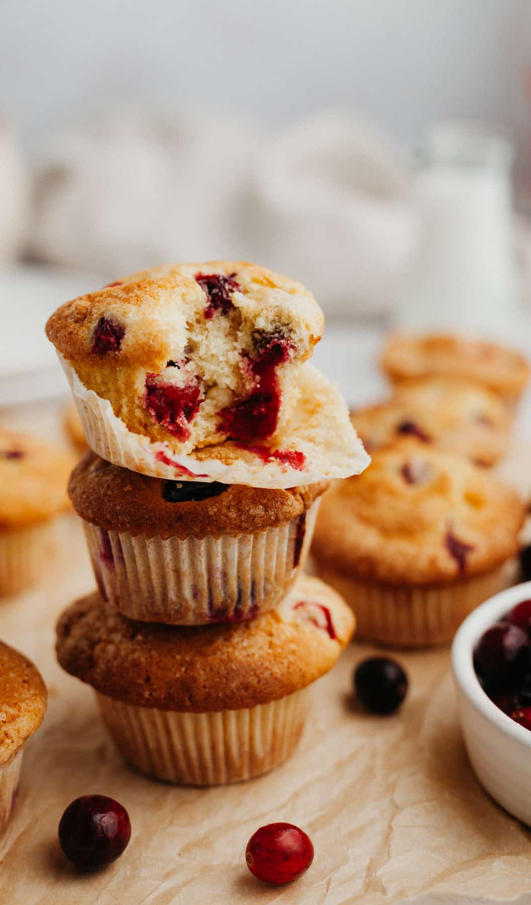 A stack of cranberry muffins on parchment paper.