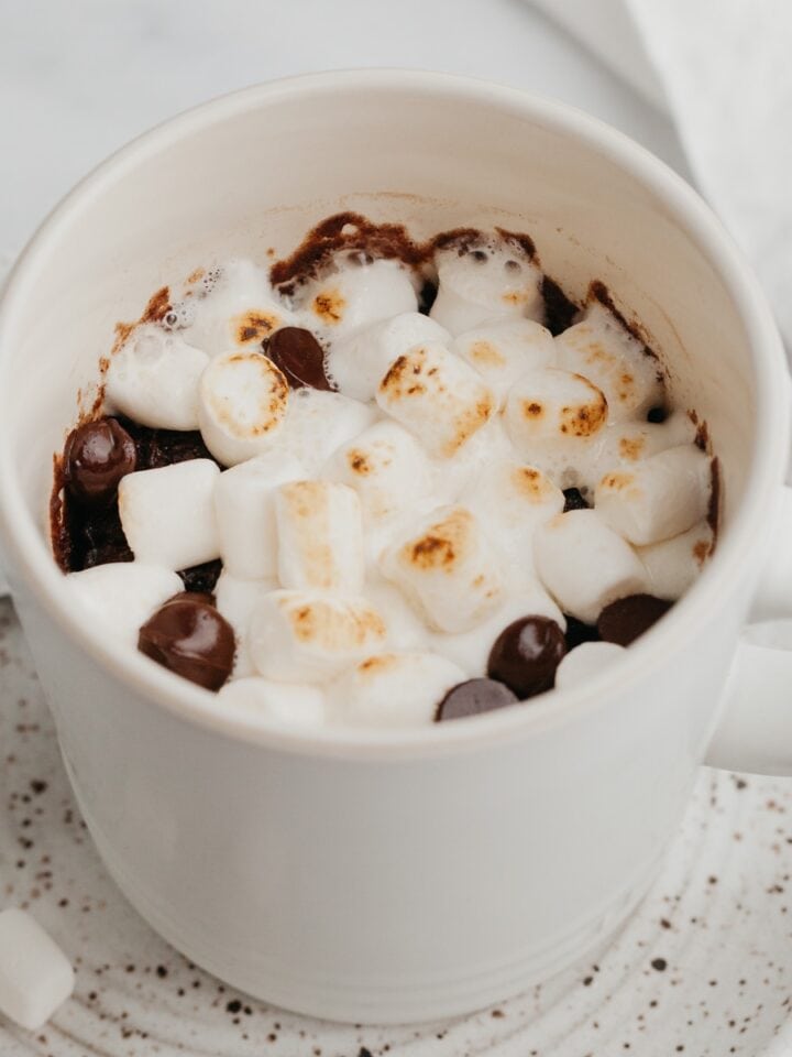 A white mug with a chocolate mug cake and marshmallows.