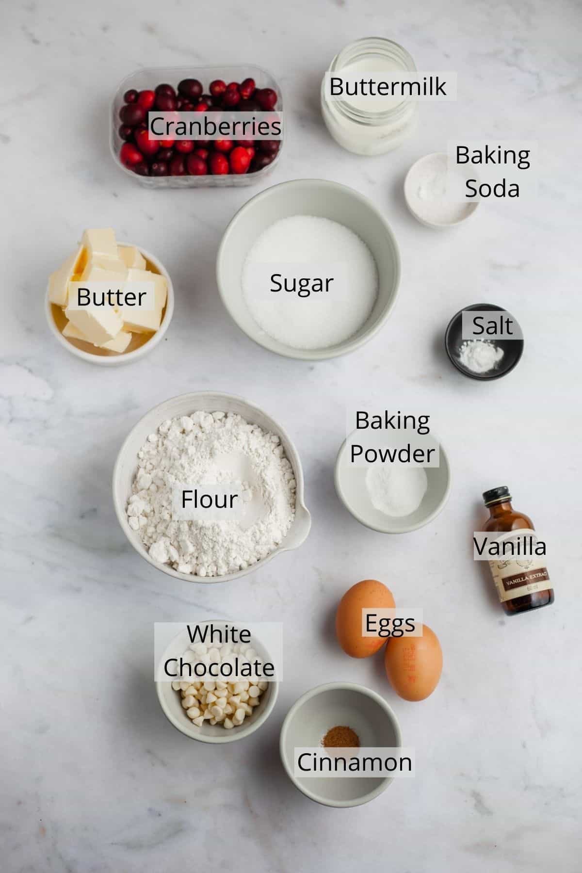 All the ingredients needed for cranberry white chocolate muffins weighed out in small bowls.