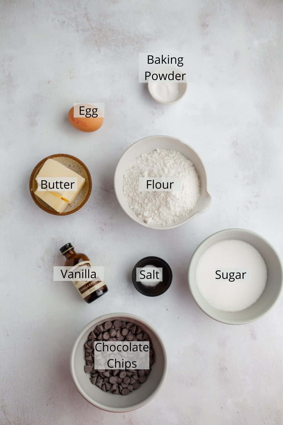 ingredients for chocolate chip sugar cookies weighed out in small bowls.