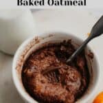chocolate orange baked oats in a small white ramekin, there is a spoon in the oats.