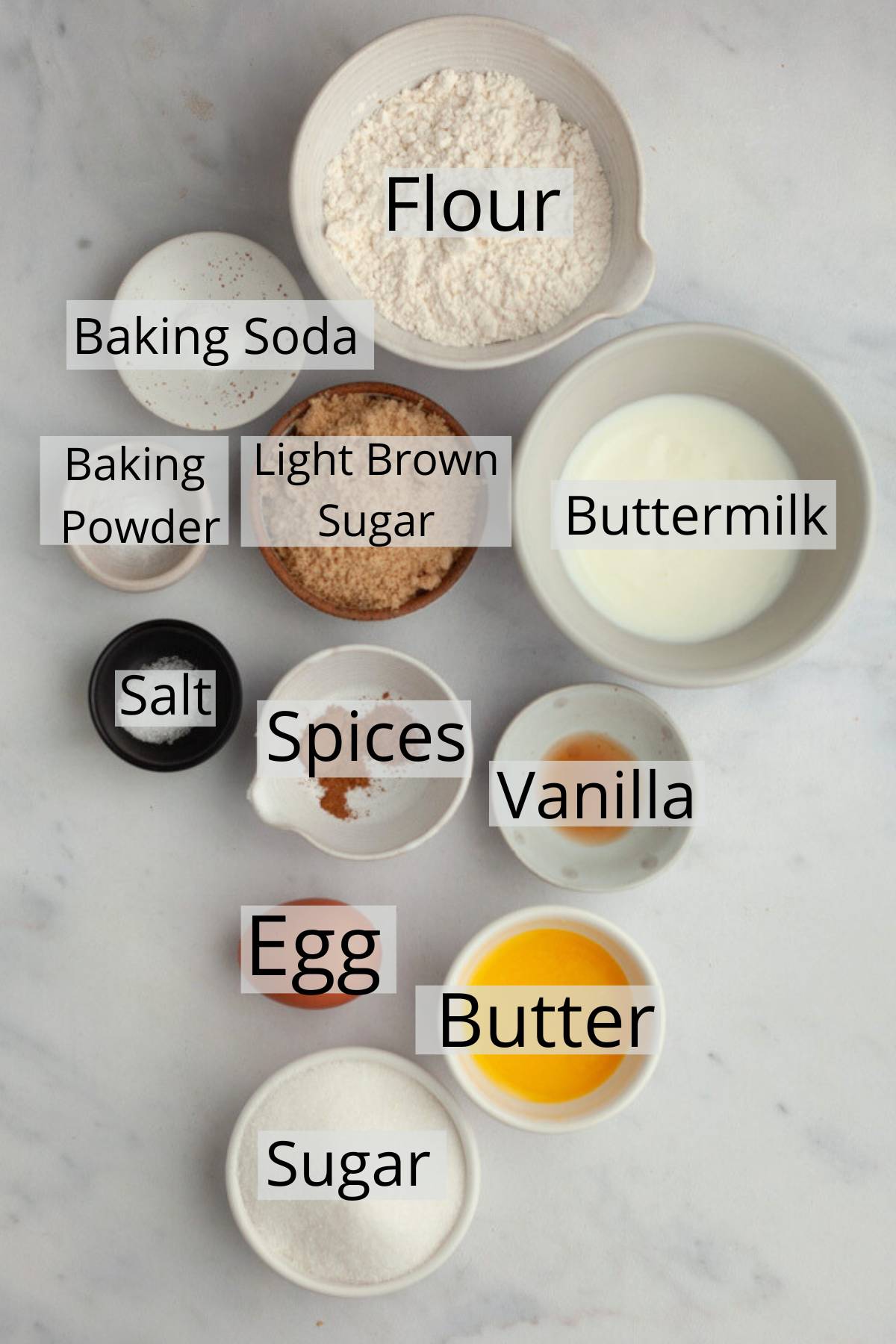All the ingredients needed to make cinnamon donuts, weighed out into small bowls.