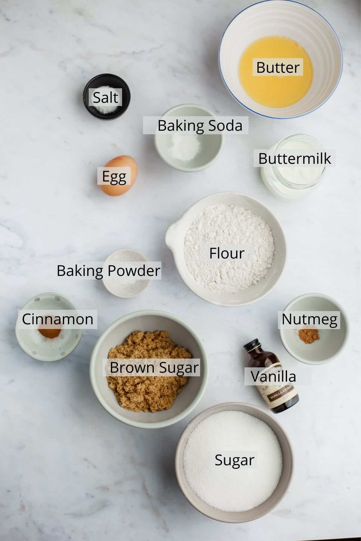 all the ingredients for cinnamon sugar doughnuts weighed out in small bowls.
