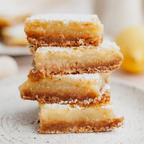 a stack of four lemon bars on a small plate.
